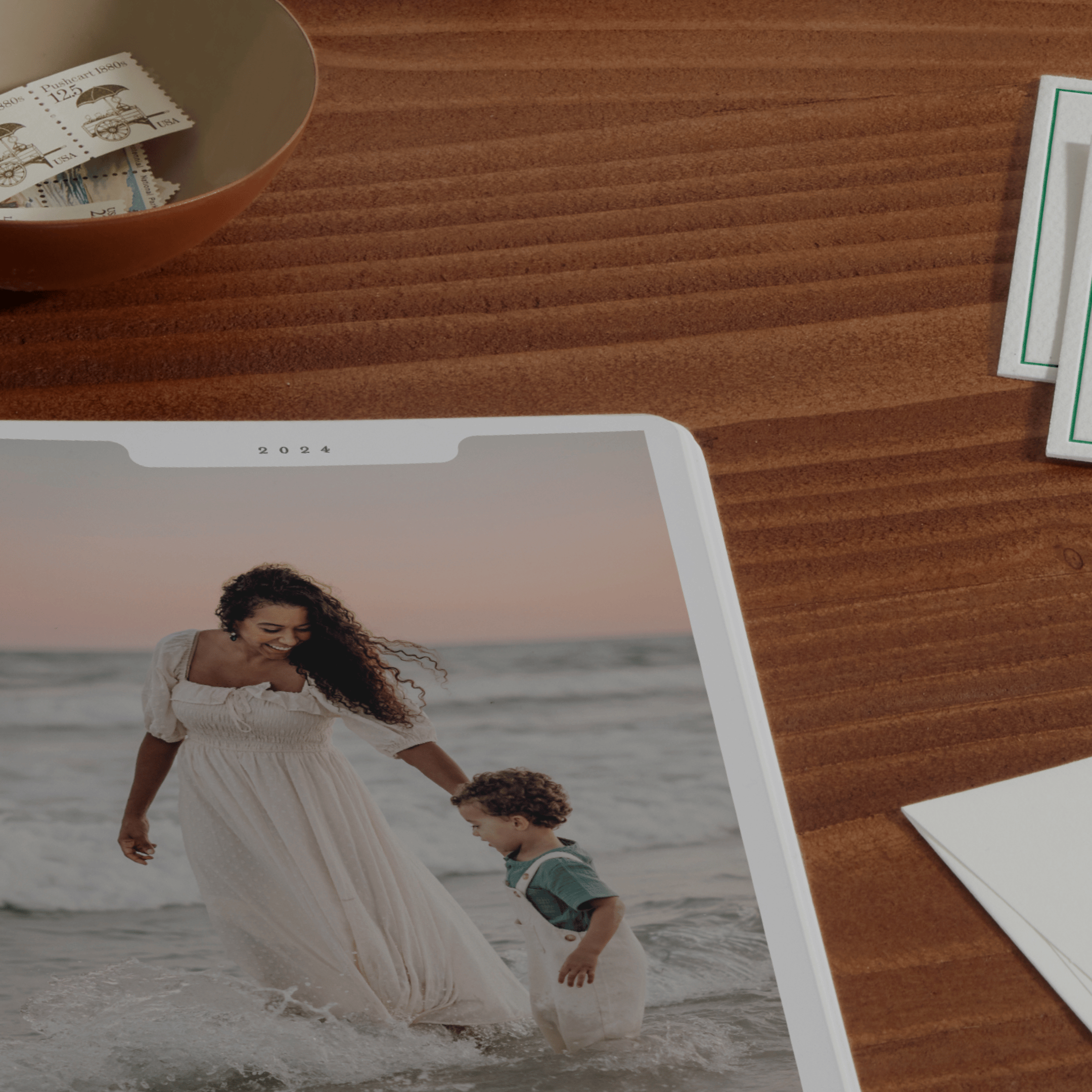 Close-up of a table, showing part of print of a woman and her kid on a beach